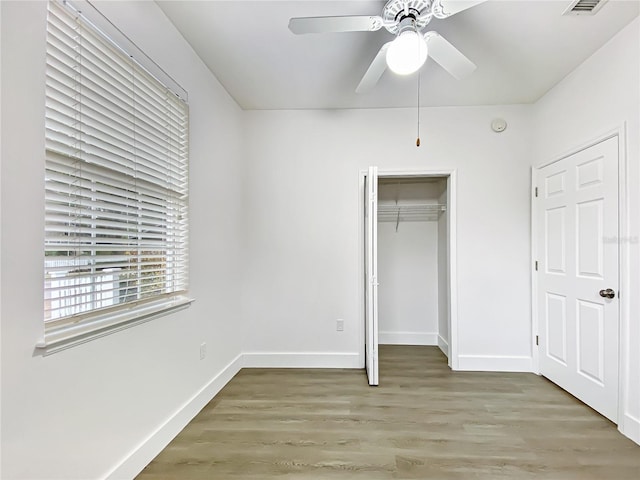 unfurnished bedroom with ceiling fan, hardwood / wood-style floors, and a closet