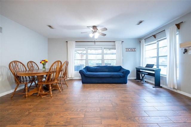 living room with ceiling fan, dark wood-type flooring, and a wealth of natural light