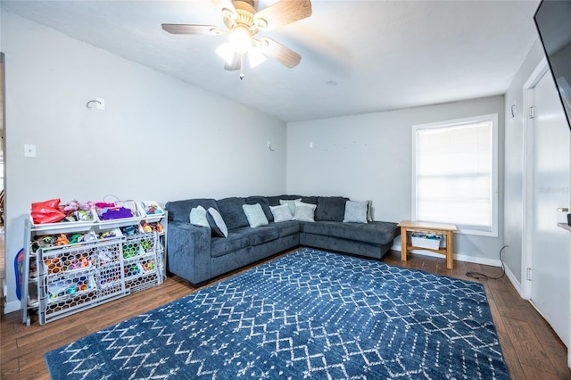 living room with dark wood-type flooring and ceiling fan