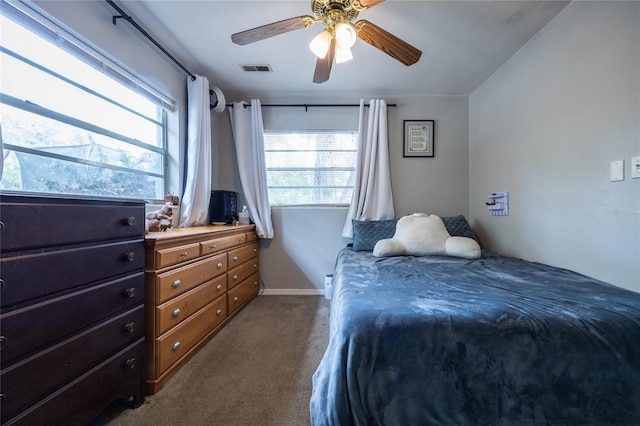 bedroom with ceiling fan, carpet, and multiple windows