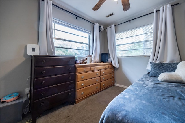 bedroom featuring ceiling fan, multiple windows, and carpet floors