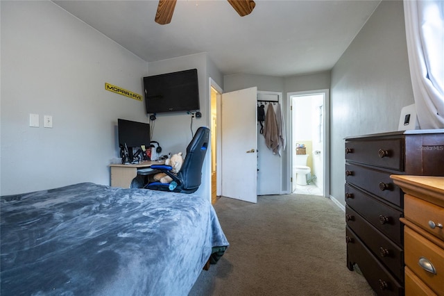 bedroom with a spacious closet, dark colored carpet, a closet, ceiling fan, and ensuite bathroom