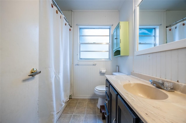 bathroom with toilet, vanity, and ornamental molding