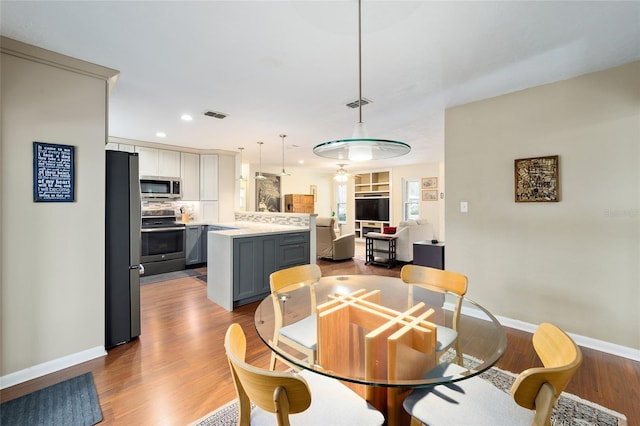 dining space with ceiling fan and light hardwood / wood-style flooring