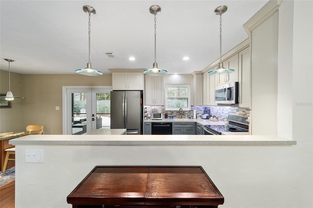 kitchen with kitchen peninsula, decorative backsplash, hanging light fixtures, stainless steel appliances, and french doors