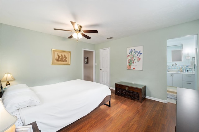 bedroom with ceiling fan, ensuite bathroom, and dark hardwood / wood-style floors