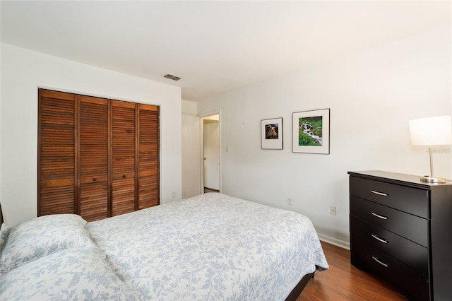 bedroom with a closet and dark hardwood / wood-style floors