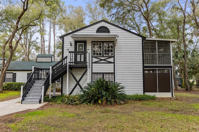 view of front of home featuring a front yard and a sunroom