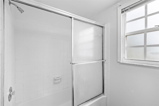 bathroom featuring combined bath / shower with glass door