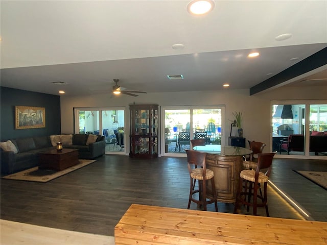 interior space with beamed ceiling, ceiling fan, and dark hardwood / wood-style flooring