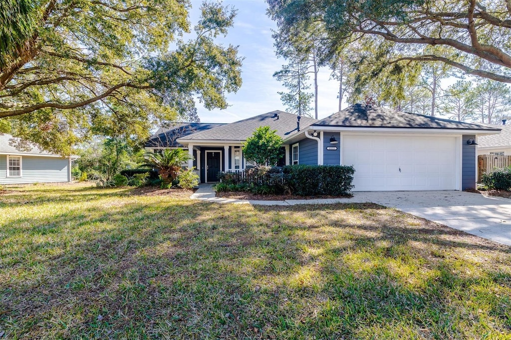 single story home featuring a garage and a front lawn