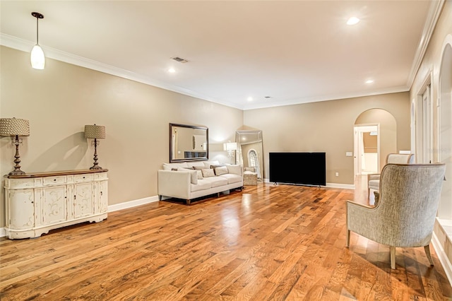 living room with ornamental molding and light hardwood / wood-style floors