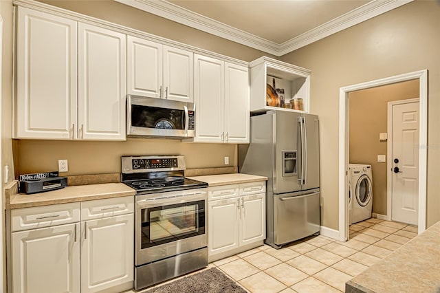 kitchen with light tile patterned flooring, appliances with stainless steel finishes, washer / clothes dryer, white cabinetry, and crown molding