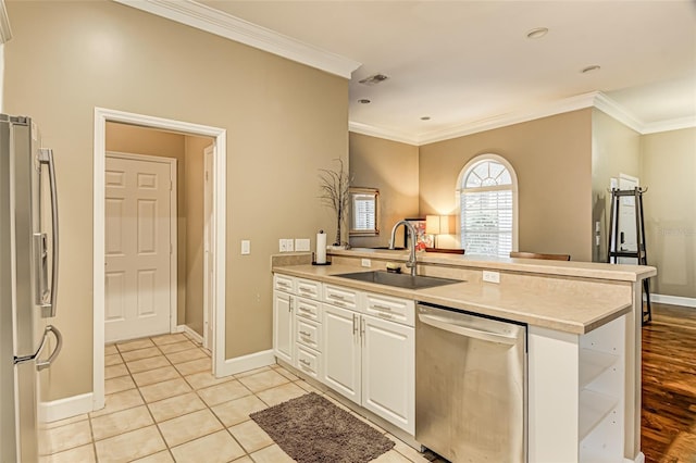 kitchen with white cabinetry, sink, stainless steel appliances, and kitchen peninsula