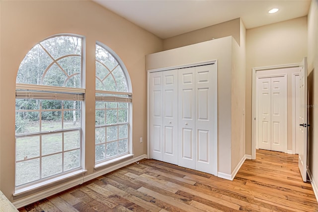 unfurnished bedroom with light hardwood / wood-style floors and a closet