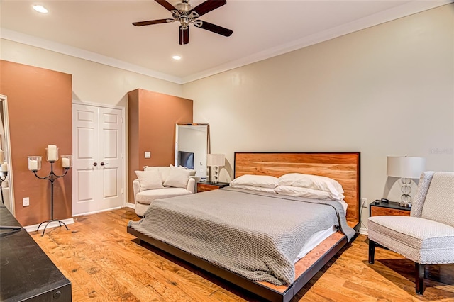 bedroom with crown molding, ceiling fan, and light hardwood / wood-style floors