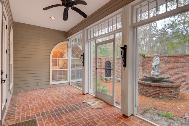 unfurnished sunroom with a healthy amount of sunlight and ceiling fan