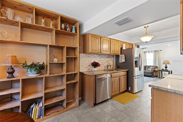 kitchen featuring sink, decorative light fixtures, stainless steel appliances, light stone countertops, and backsplash