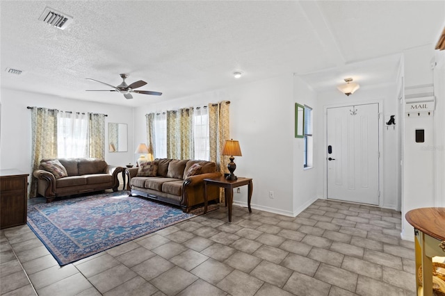 living room with ceiling fan and a textured ceiling