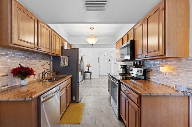 kitchen featuring sink, stainless steel appliances, tasteful backsplash, light tile patterned flooring, and decorative light fixtures