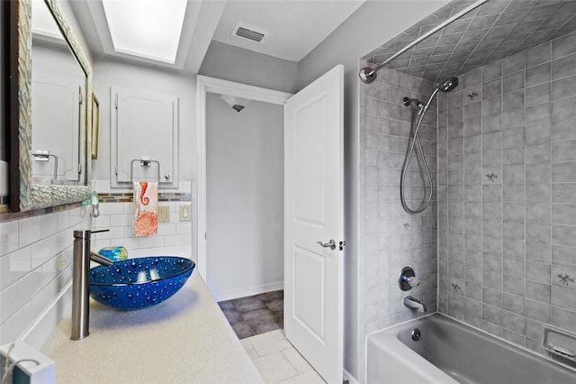 bathroom with sink and tiled shower / bath combo