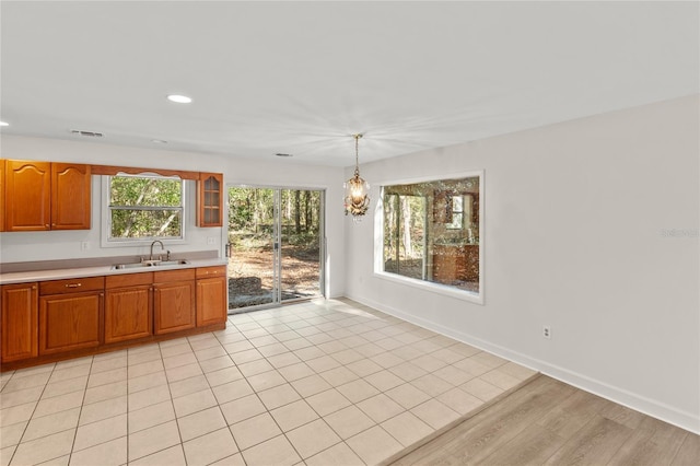 kitchen with sink, hanging light fixtures, and light hardwood / wood-style flooring