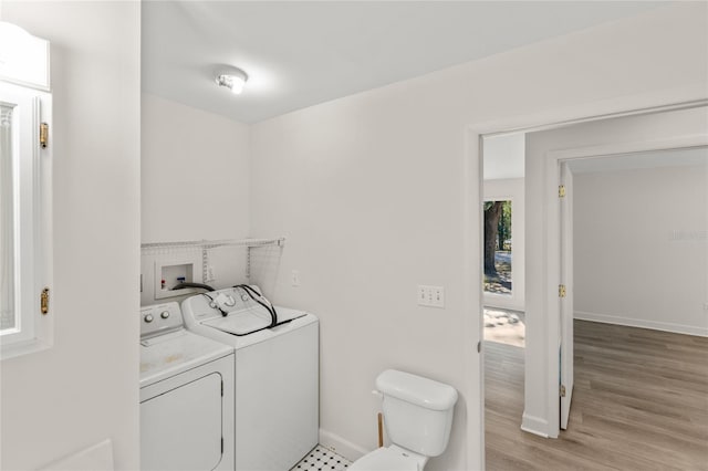 washroom with light hardwood / wood-style flooring and washer and clothes dryer