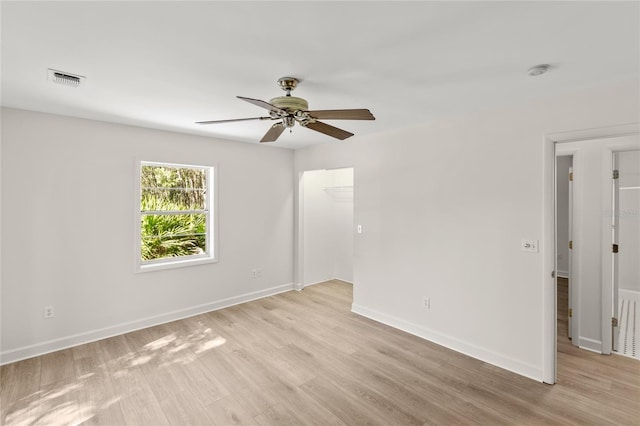 spare room with light wood-type flooring and ceiling fan