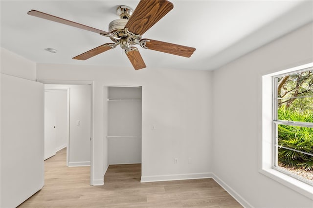 unfurnished bedroom with light hardwood / wood-style floors, a closet, and ceiling fan