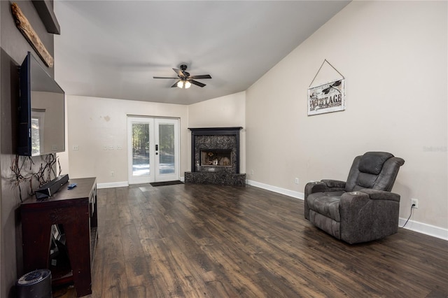 living room with dark wood-type flooring, ceiling fan, a high end fireplace, vaulted ceiling, and french doors