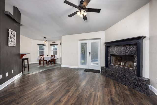 unfurnished living room with hardwood / wood-style flooring, ceiling fan, a fireplace, and french doors