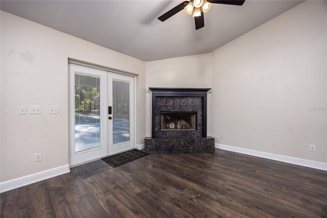 unfurnished living room with a high end fireplace, dark hardwood / wood-style floors, ceiling fan, and french doors