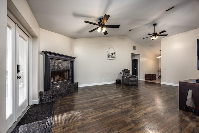 living room with dark hardwood / wood-style flooring, lofted ceiling, a premium fireplace, and ceiling fan