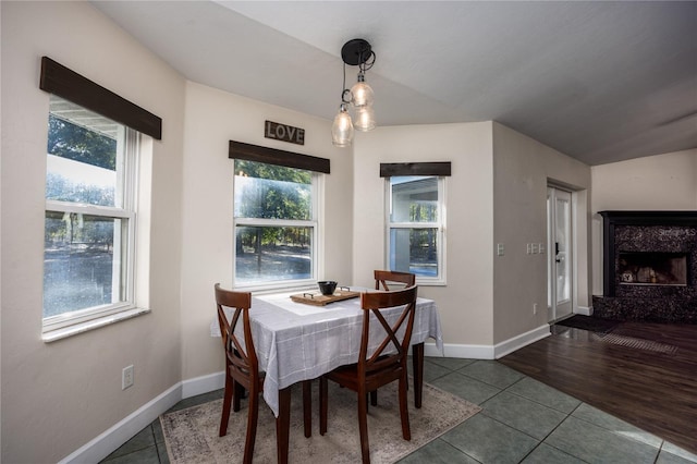 dining space with tile patterned floors and a fireplace