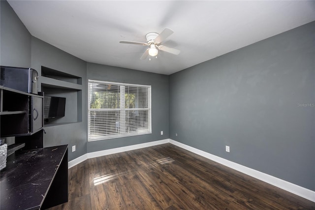 interior space with dark wood-type flooring and ceiling fan