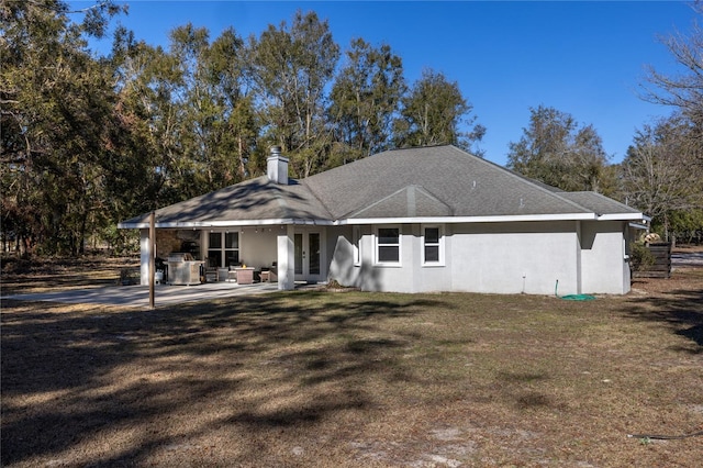 back of property with a yard and a patio area