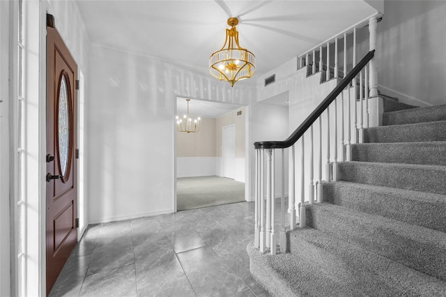 foyer entrance with an inviting chandelier and carpet