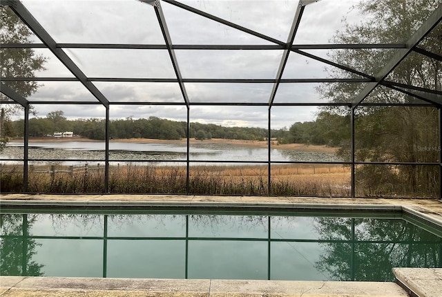 view of swimming pool featuring a water view and glass enclosure