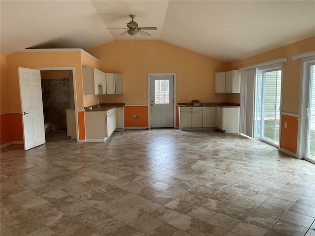 kitchen with ceiling fan, white cabinets, vaulted ceiling, and plenty of natural light