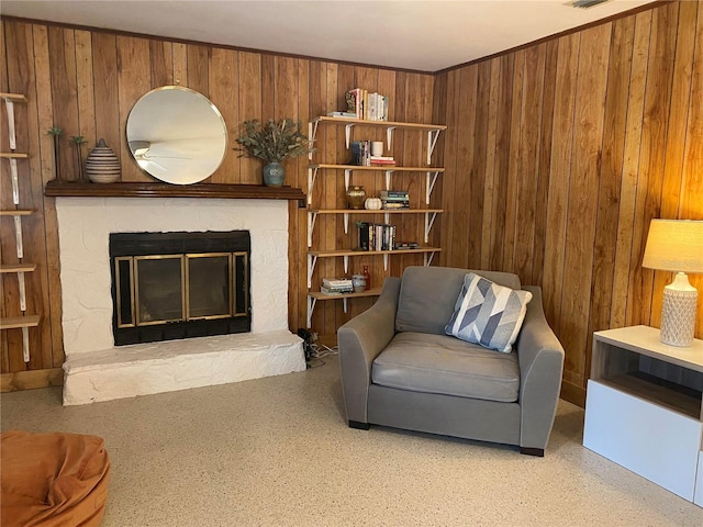 living room with a fireplace and wooden walls