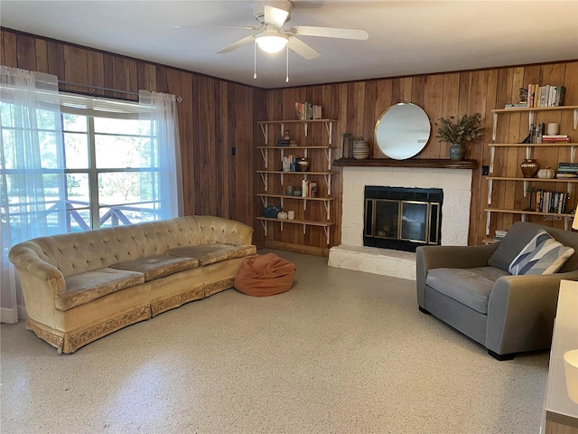 living room featuring ceiling fan and wooden walls