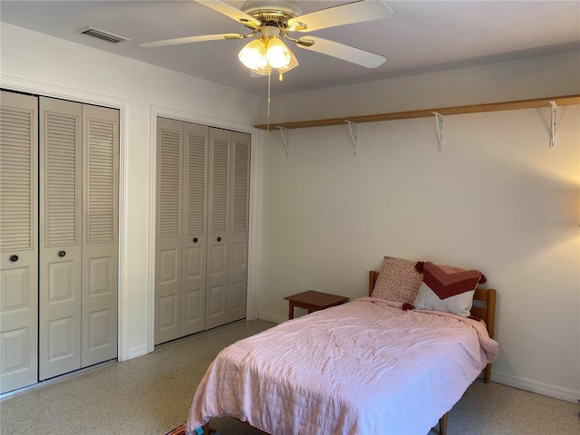 bedroom featuring ceiling fan and multiple closets