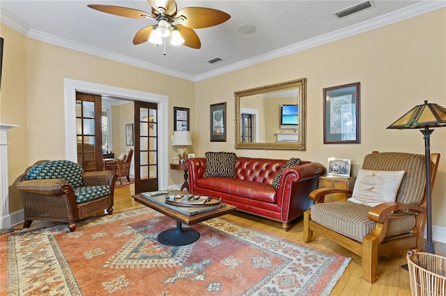 living room featuring hardwood / wood-style flooring, ceiling fan, ornamental molding, and french doors