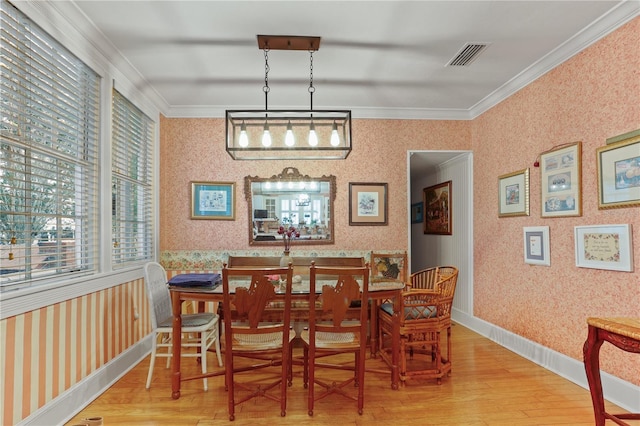 dining room with crown molding and wood-type flooring