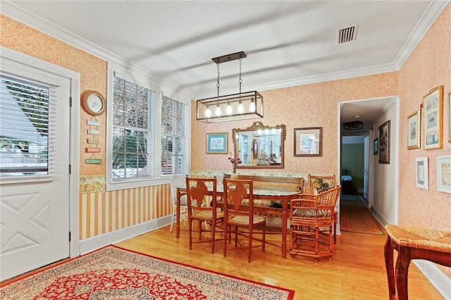 dining area with hardwood / wood-style flooring and crown molding