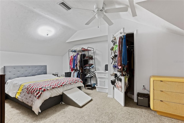 bedroom with lofted ceiling, a textured ceiling, carpet, and ceiling fan