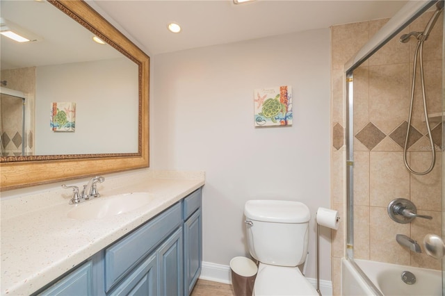 full bathroom with enclosed tub / shower combo, vanity, and toilet