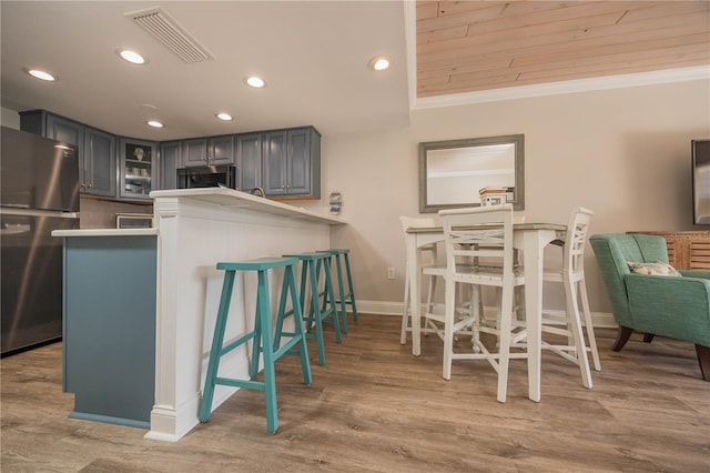 kitchen with gray cabinets, wood ceiling, kitchen peninsula, stainless steel appliances, and crown molding