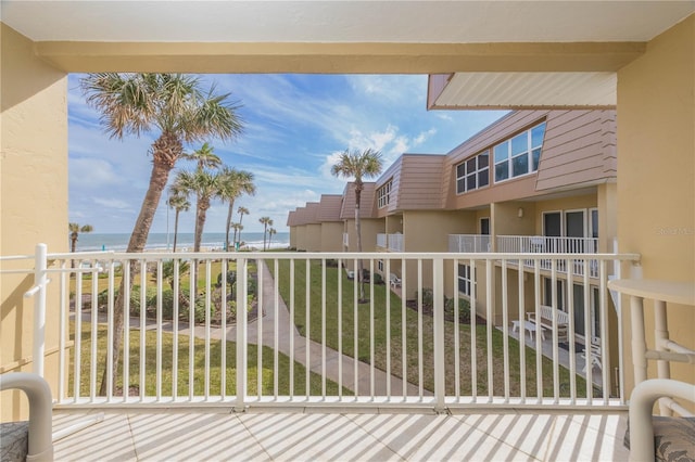 balcony with a water view and a view of the beach