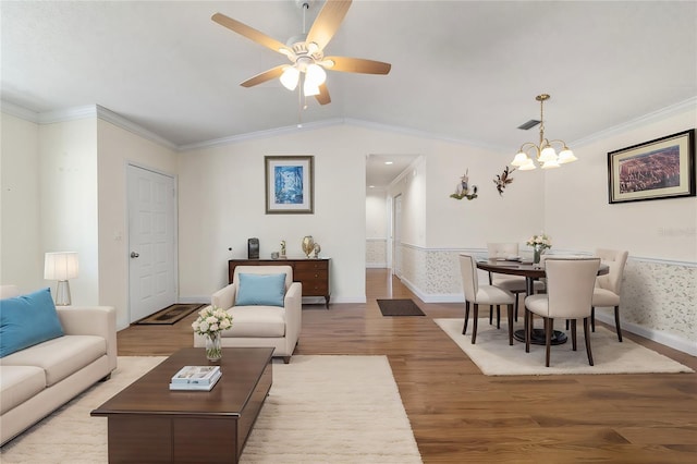 living room with ornamental molding, lofted ceiling, ceiling fan with notable chandelier, and light hardwood / wood-style floors